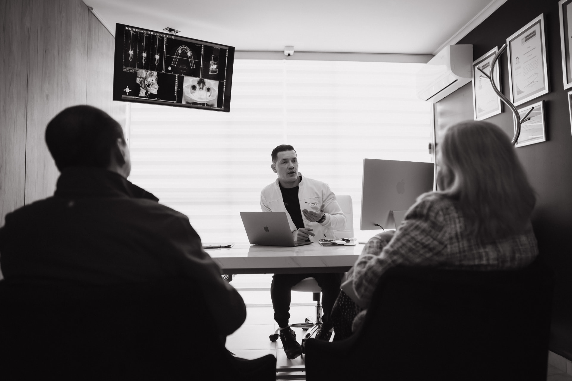 Dr. Robert Rivera explicando un caso a dos pacientes en su consultorio